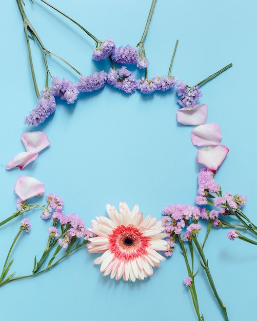 High angle view of floral wreath pattern frame on blue background