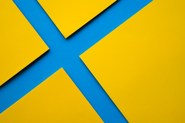 High angle view of four yellow craft papers on blue surface