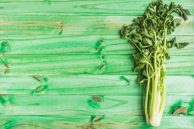 High angle view of fresh celery on green wooden background