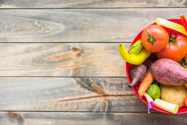 High angle view of fresh vegetables in bowl on wooden background