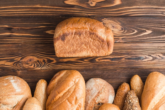 High angle view of freshly baked breads on wooden backdrop