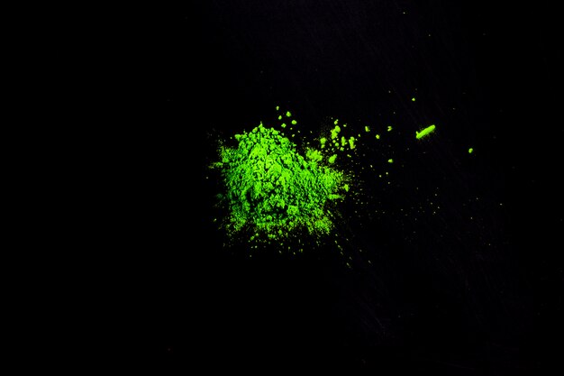 High angle view of green holi color over black card