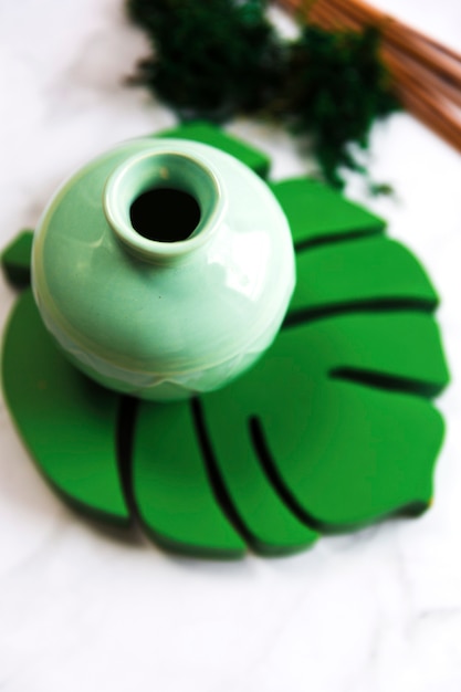 モンスターの葉のコースター上の緑のスパセラミック陶器の高い角度のビュー