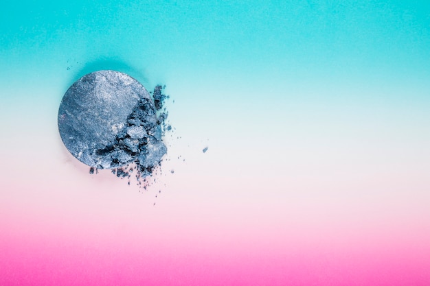 High angle view of grey powder ball on multi colored background