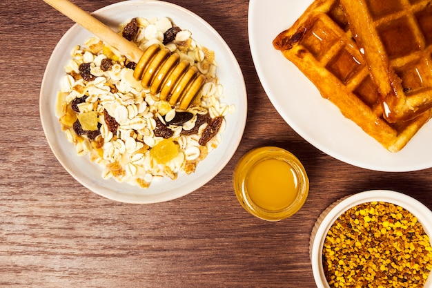 High angle view of healthy oats with waffle and honey