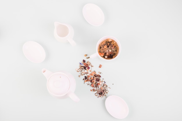 High angle view of herbal tea near crockery on white background