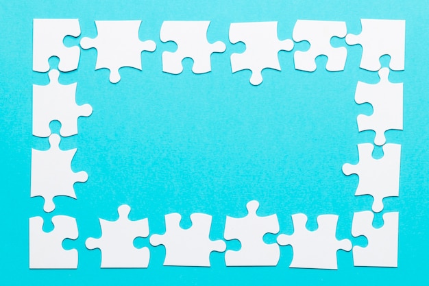 High angle view of jigsaw puzzle frame on blue backdrop