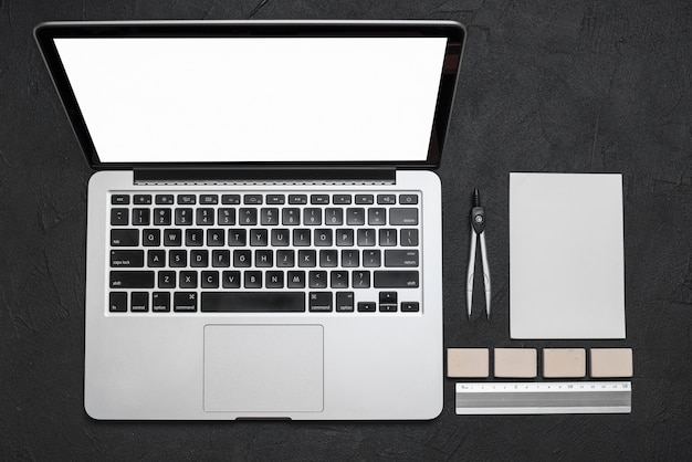 High angle view of laptop and stationeries on black background