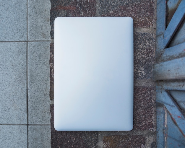 Foto gratuita vista dell'angolo alto di un computer portatile sulla pavimentazione di pietra