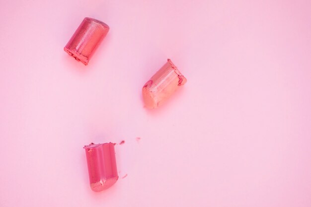 High angle view of lipsticks on pink background