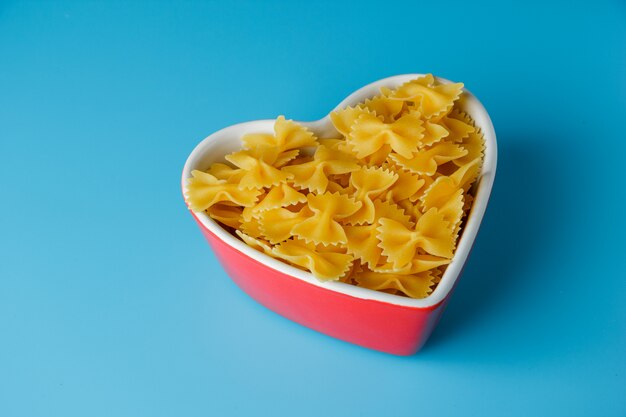 High angle view macaroni pasta in heart shaped bowl