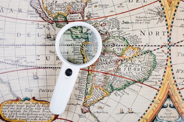 High angle view of magnifying glass on old world map