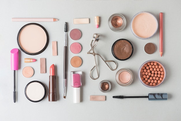 High angle view of makeup products arranged in rectangular shape on white background