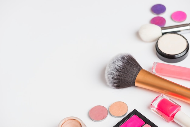 High angle view of makeup products on white backdrop
