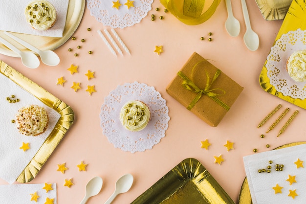 High angle view of muffins and gifts on decorative colored background