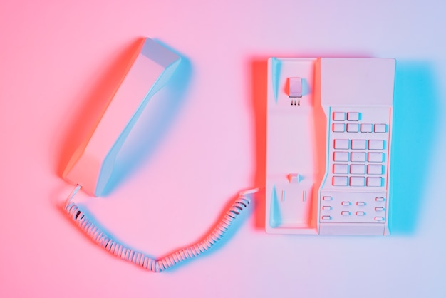 Бесплатное фото Высокий угол обзора розовый ретро стационарный телефон с приемником