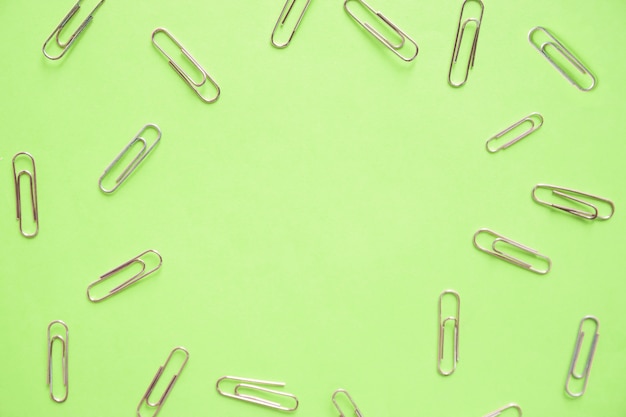 High angle view of paper clips on green background