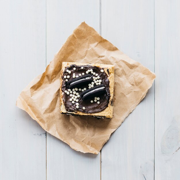 High angle view of pastry decorated with cookies on wooden plank