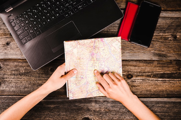 High angle view of a person's Hand pointing at location on map