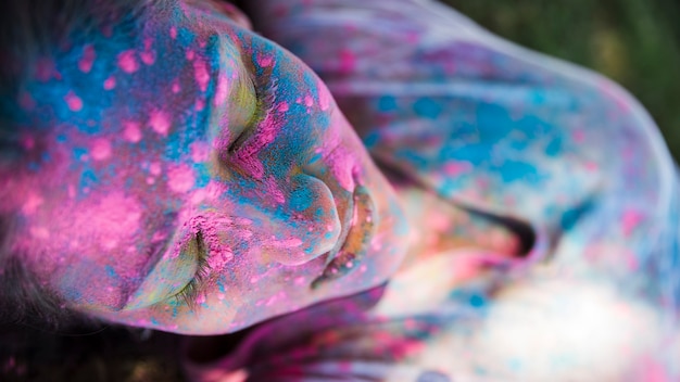 High angle view of pink and blue holi color on woman's face