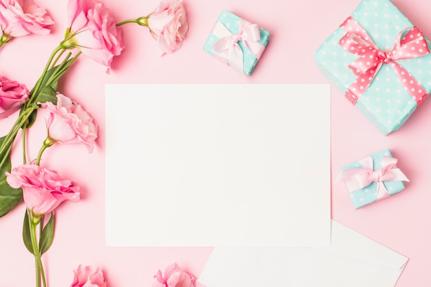 Высокий угол обзора розового цветка; белый чистый лист бумаги и декоративная подарочная коробка