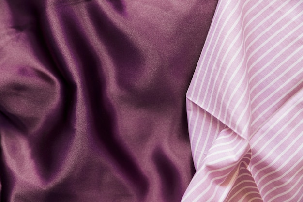High angle view of pink line pattern and plain purple textile