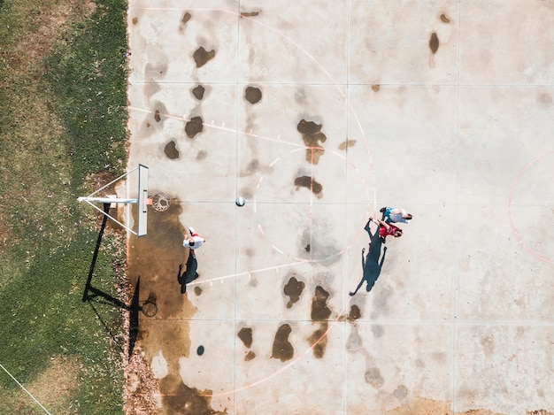 Free photo high angle view of player throwing basketball in the hoop