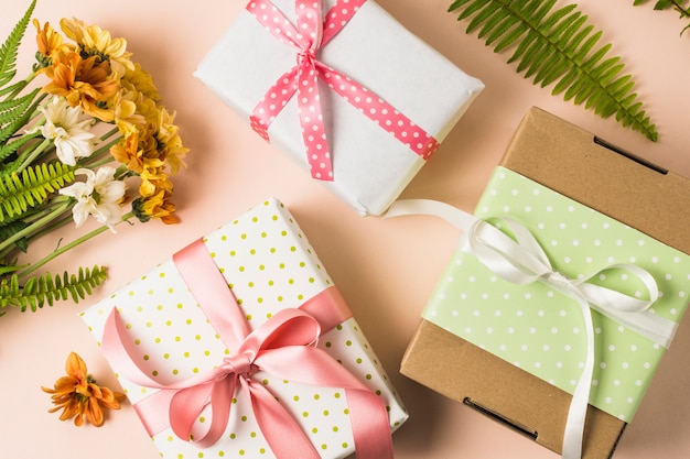 High angle view of present boxes and flower bouquet with leaves