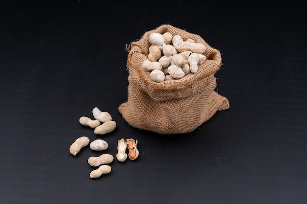 High angle view raw peanuts in sack on black horizontal