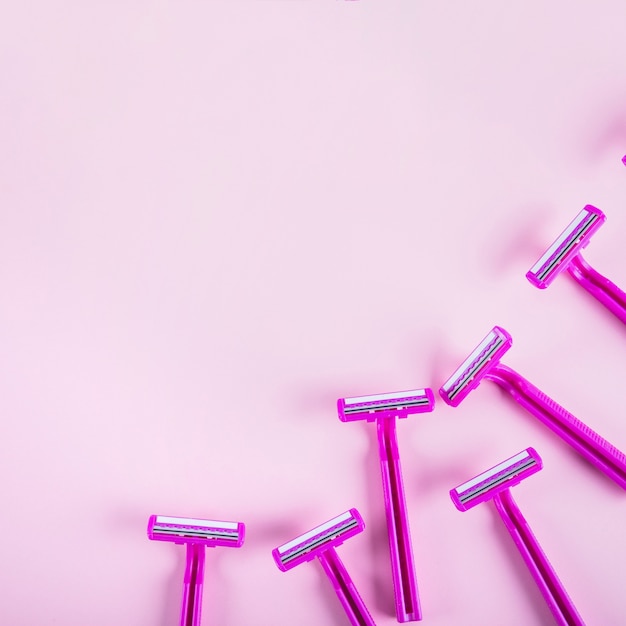 High angle view of razors on pink backdrop