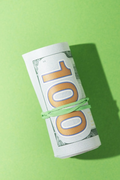 High angle view of rolled up banknotes on green backdrop