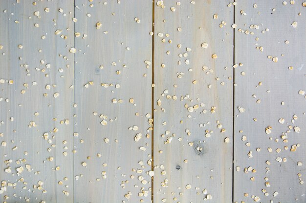 High angle view of scattered oats on wooden background