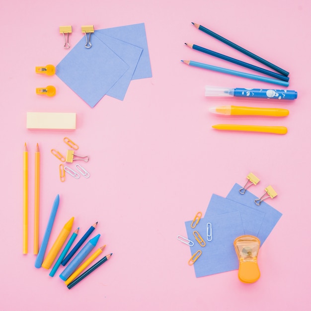 Free photo high angle view of school supplies over pink wallpaper