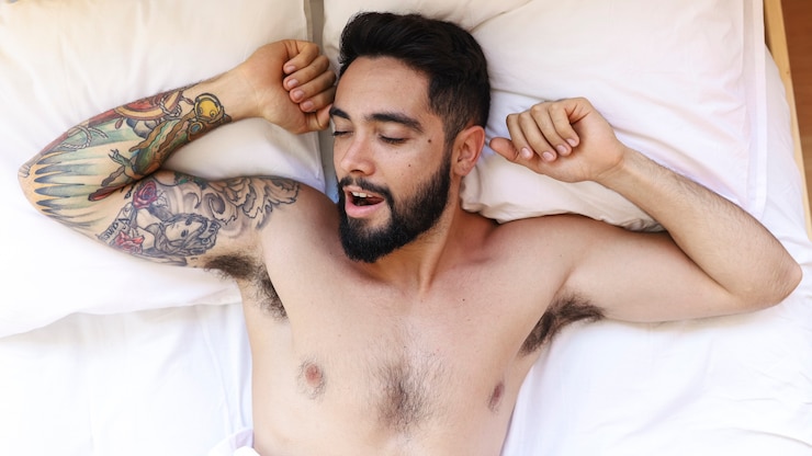 Free Photo high angle view of a shirtless young man sleeping on bed