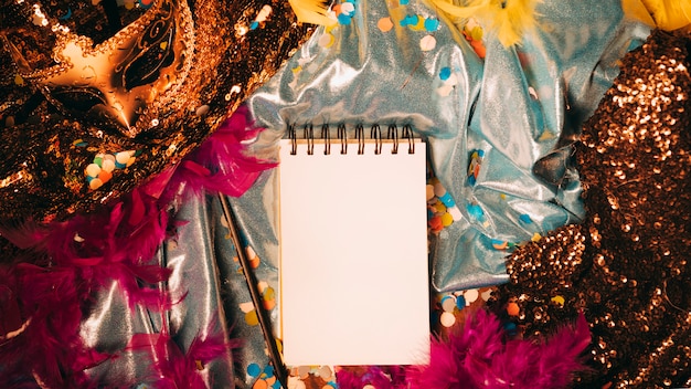 High angle view of spiral blank notepad with carnival props