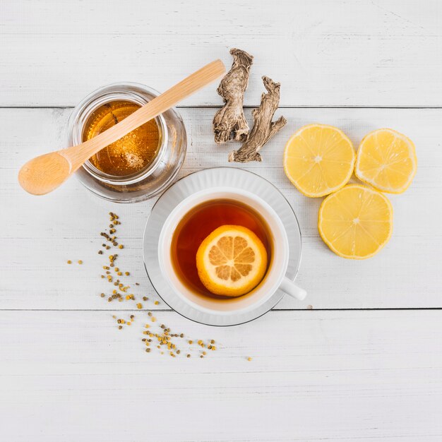 Высокий угол зрения сладкого меда; лимонный чай и имбирь на деревянном фоне