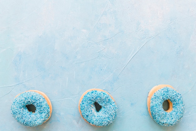 Free photo high angle view of tasty donuts on blue surface