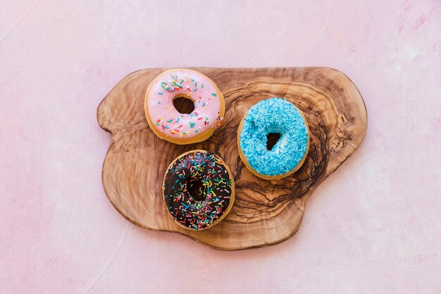 High angle view of tasty donuts on wooden chopping board