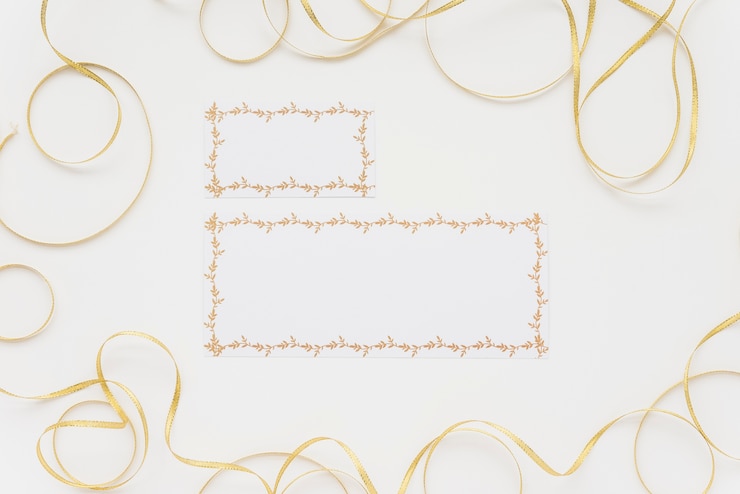 Free Photo high angle view of two blank cards surrounded with ribbons on white surface
