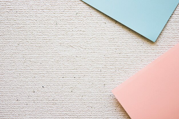 High angle view of two grey and pink cardboard papers on concrete background