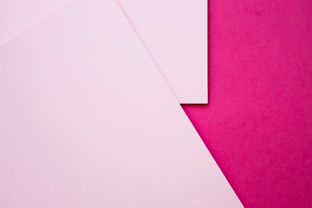 High angle view of two pink craftpapers on magenta background