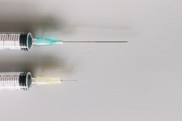 High angle view of two syringes on white background