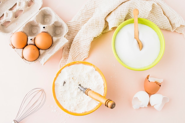 High angle view of various baking ingredients on colored background