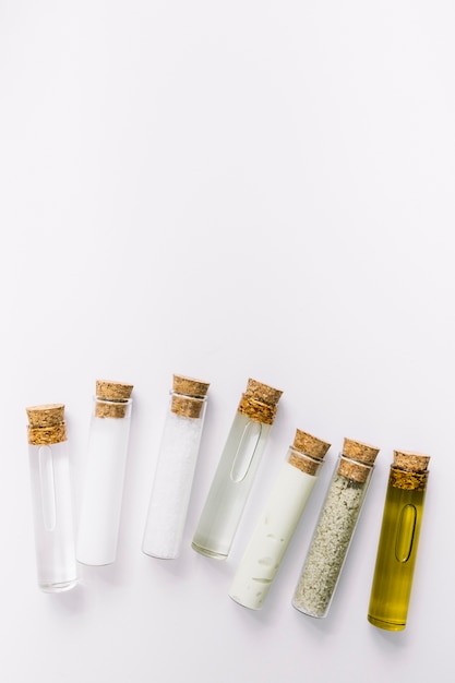 High angle view of various cosmetic test tubes on white background