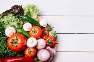 Free photo high angle view of various fresh vegetables on wooden table