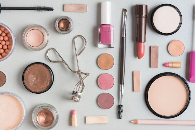 Free photo high angle view of various makeup products on white surface