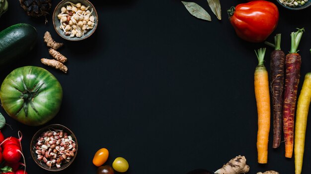 High angle view of various raw vegetables on black background