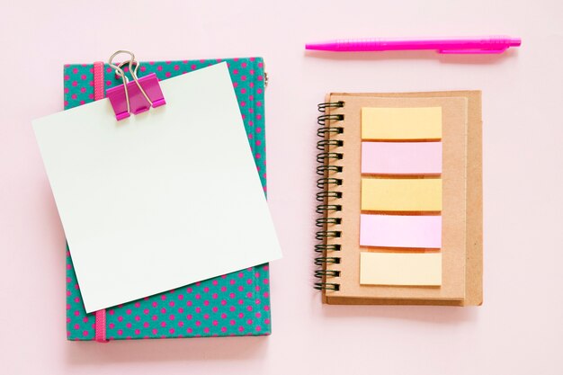 High angle view of various stationeries on pink background