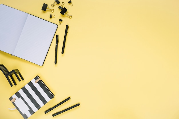 High angle view of various stationeries on yellow backdrop