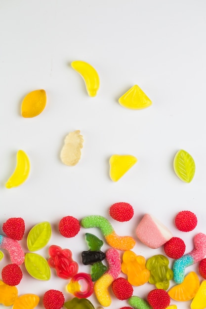 High angle view of various sweet candies on white background